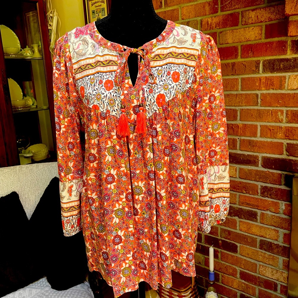 Printed peach floral top with tassels.